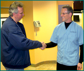Dr. Treinkman shakes hand with Chicago area dental patient at East Village Dental Centre.