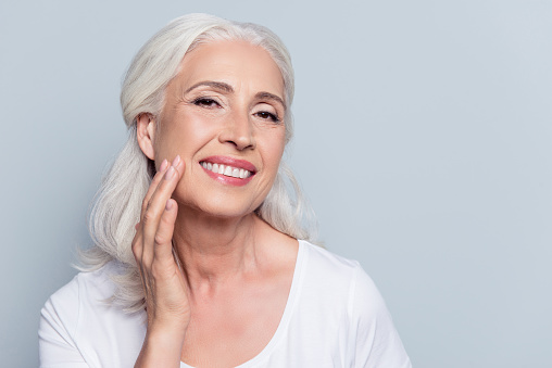 Woman smiling after her dental implant procedure at East Village Dental Centre.